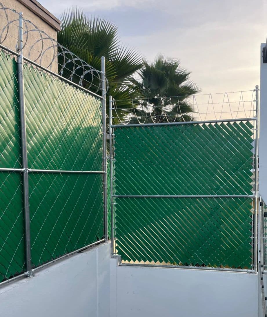 Cerco ciclónico con cintilla verde y concertina instalado por Cercocentro